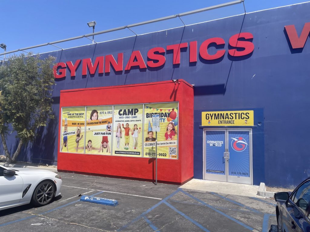 Gymnastics World Facility Entrance Door and window case showing activities and logo.
